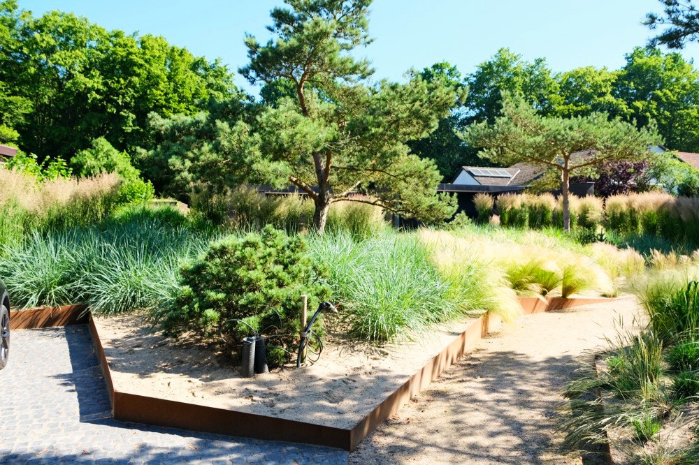 Naturnah gestalteter Garten mit Gräsern, Solitärgehölz und Sitzplatz